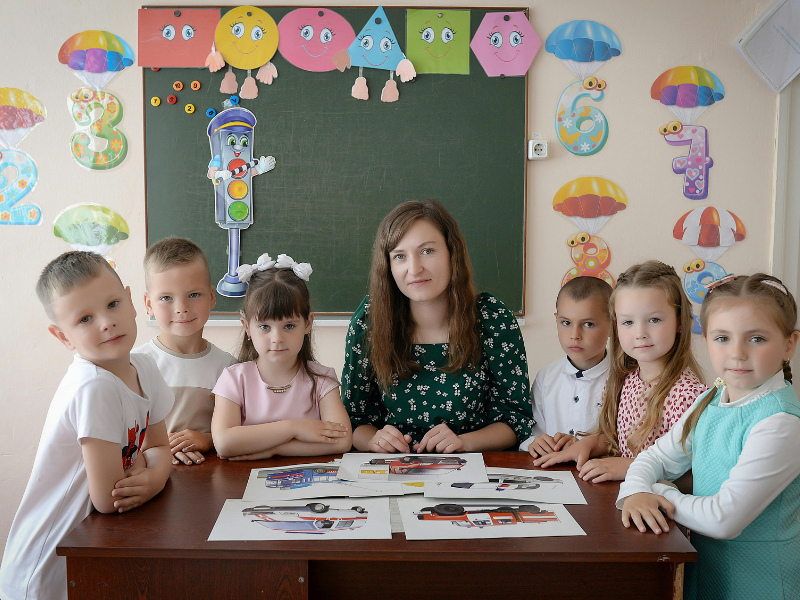 Children wd teacher on table